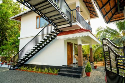 a house with a staircase in front of it at Coconut Palms Village Homestay in Kumarakom