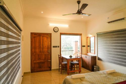 a bedroom with a bed and a table and a clock at Coconut Palms Village Homestay in Kumarakom