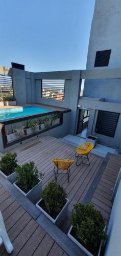 聖米格爾德圖庫曼的住宿－Lavalle 12 - Bon Repos，一个带黄色桌椅的庭院和一个游泳池