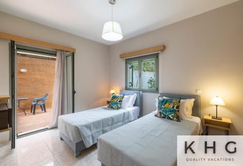 a bedroom with two beds and a sliding glass door at Hermes luxury apartment in Vlachata village! in Vlachata