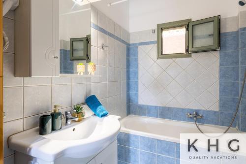 a bathroom with a white sink and a bath tub at Hermes luxury apartment in Vlachata village! in Vlachata