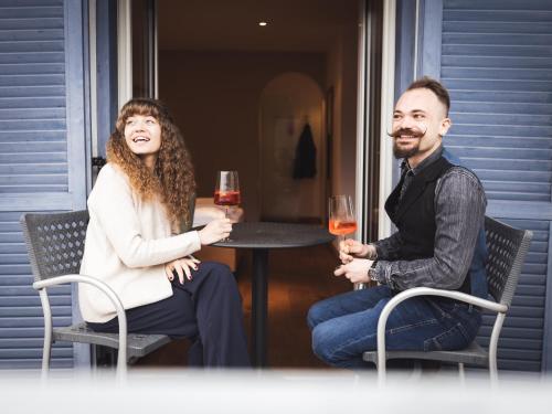 a man and woman sitting at a table with glasses of wine at Hotel Panorama in Rablà