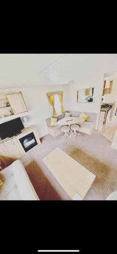 a living room with couches and tables in a room at Static Caravan Marine Holiday Park in Rhyl