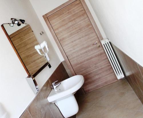 a bathroom with a white toilet and a wooden door at La Filanda in Brescia