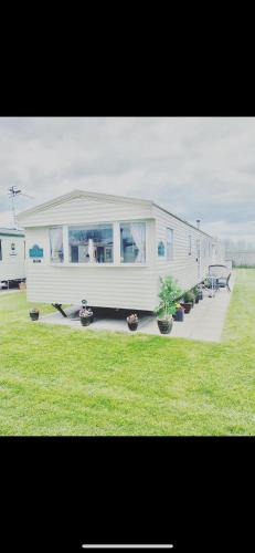 a large white trailer with plants in a field at Static Caravan Marine Holiday Park in Rhyl