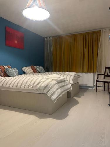um quarto com uma cama grande e uma parede azul em Private Room 4 Near Southmead Hospital, Bristol em Bristol