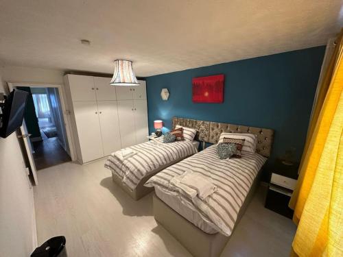 布里斯托的住宿－Private Room 4 Near Southmead Hospital, Bristol，一间卧室设有两张床和蓝色的墙壁