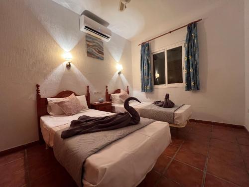 ein Zimmer mit 2 Betten und einem Schwan darauf in der Unterkunft Cd-1383 Three Bedroom Villa With Pool in Viñuela