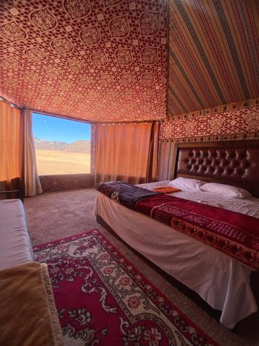 a bedroom with a bed and a view of a field at Wadi Rum Desert Bedouins in Wadi Rum