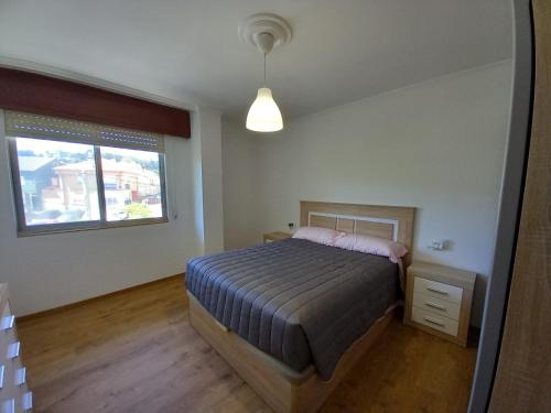 a bedroom with a bed and a window at SOLPOR DO VERAN in Ribeira