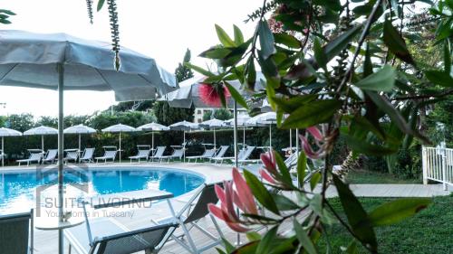 een zwembad met ligstoelen en een parasol bij Home Away Livorno - Suite Livorno Holiday Home Group in Livorno