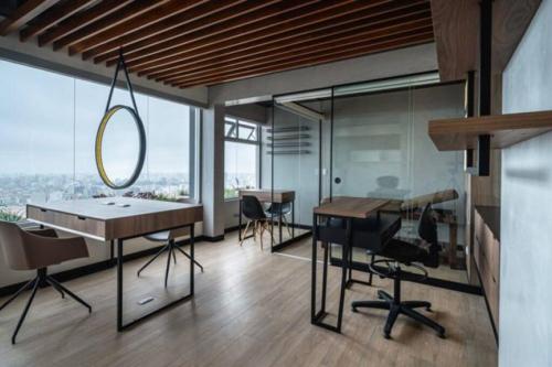 Habitación con escritorio, sillas y espejo. en Met Moderno Departamento, en Lima