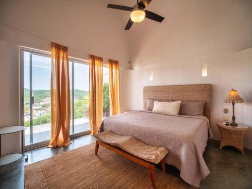 a bedroom with a bed and a large window at Casa Volare - Contemporary Oceanfront Villa in Santa Cruz Huatulco