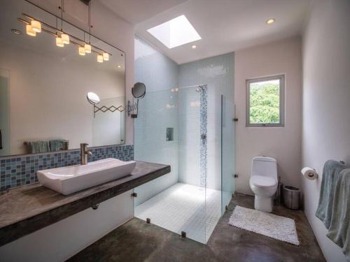 a bathroom with a sink and a shower and a toilet at Casa Volare - Contemporary Oceanfront Villa in Santa Cruz Huatulco