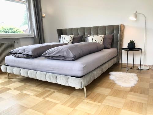 un sofá con almohadas en una habitación en CROWN LIVING Design Apartment - 2 Schlafzimmer - Küche - gratis Parkplatz - Abstellraum für Fahrräder/Ski, en Mäder