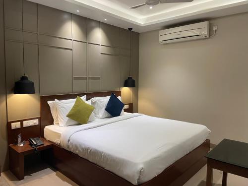 a bedroom with a bed with white sheets and pillows at Five Elements in Visakhapatnam
