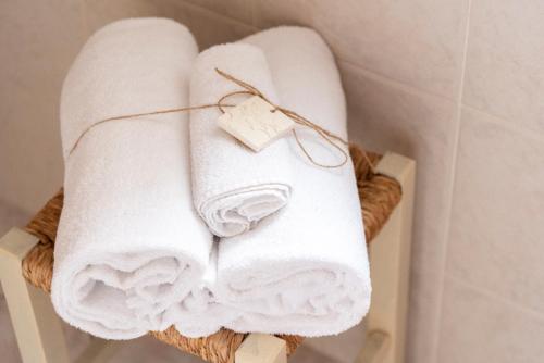 een stel handdoeken in een mand in een badkamer bij Casa Duesse in Orosei