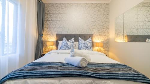 a bedroom with a bed with white towels on it at Chic Modern Midrand Escape in Midrand