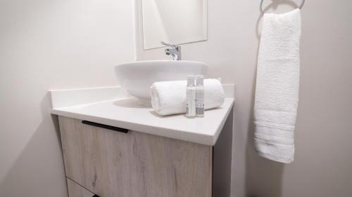 baño con lavabo blanco y toalla en Chic Modern Midrand Escape en Midrand