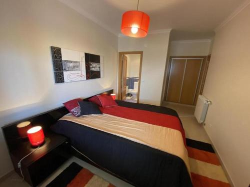 um quarto com uma cama grande e almofadas vermelhas em APARTAMENTO VISTA MAR na Lourinhã