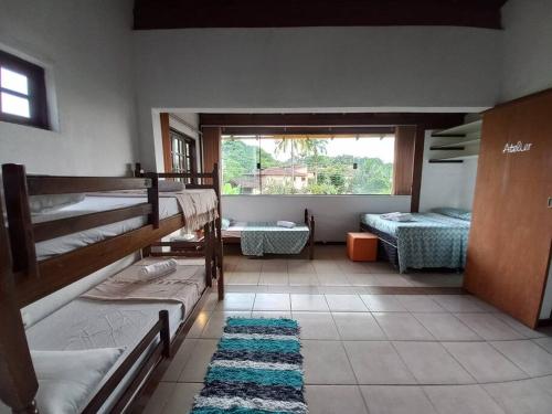 Casa Juçara Paraty في باراتي: غرفة نوم مع سرير بطابقين ونافذة