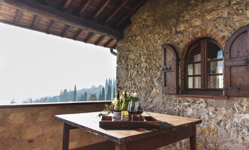 a table in front of a stone wall with a window at Collina di Verona Borgo San Mattia in Verona