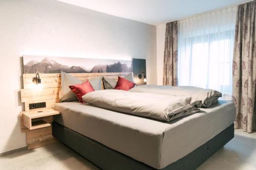 een slaapkamer met een groot bed met rode kussens bij Fonses Chalet in Waging am See