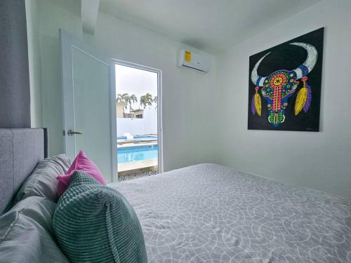 1 dormitorio con cama y vistas a la piscina en Centrally located Villa with 3 Pools -Food & Beach walking distance, en Arecibo