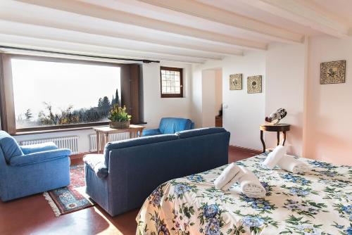Habitación con 2 sillas azules, cama y ventana en Collina di Verona Borgo San Mattia, en Verona