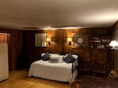 um quarto com uma cama com almofadas em Little Red Wing 50s Lake Cabin em Bradford