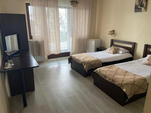 a hotel room with two beds and a desk at Casa Bavareză in Caransebeş