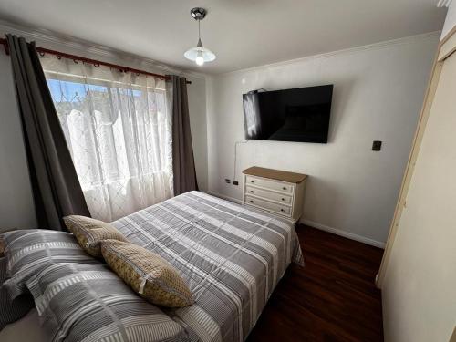 Dormitorio pequeño con cama y TV en Casa en San Pedro de la Paz, 5 personas, 2 dormitorios, gimnasio, en San Pedro de la Paz