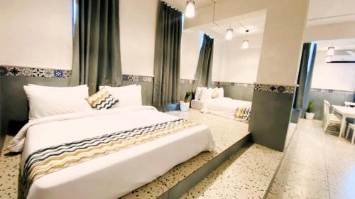 a bedroom with a large bed and a living room at Nest Beacon Resort Daman in Daman
