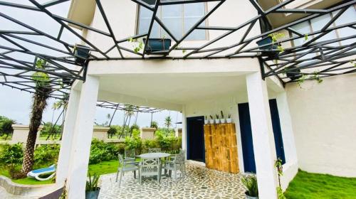a patio of a house with a table and chairs at Nest Beacon Resort Daman in Daman