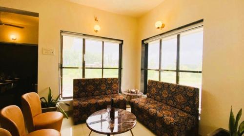 a living room with two chairs and a glass table at Nest Beacon Resort Daman in Daman