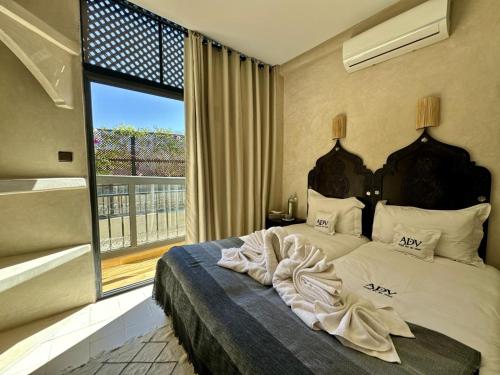 a bedroom with a large bed with a large window at Riad ART DE VIVRE avec Jacuzzi in Marrakesh