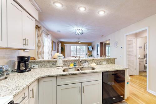 a kitchen with white cabinets and a sink at River Oaks 10D in Myrtle Beach