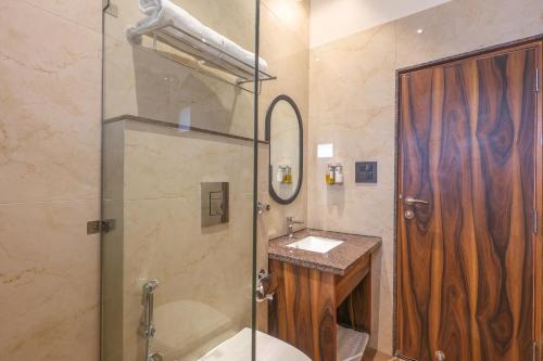 W łazience znajduje się prysznic, toaleta i umywalka. w obiekcie Hotel Lalit Palace w mieście Dehradun