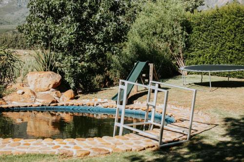 ein Wasserbad mit einem Tisch und einem Picknicktisch in der Unterkunft Mont Rouge Cottage in Tulbagh