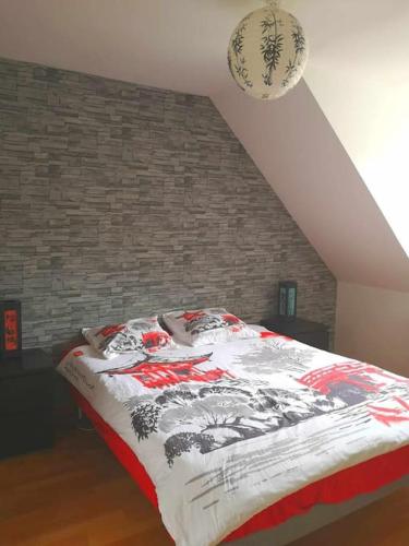 un lit dans une chambre avec un mur de briques dans l'établissement Maison Piscine et Jardin - Bethisy st Martin(Oise), à Béthisy-Saint-Martin