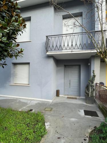 a white house with a balcony and a door at B&B IL CEDRO in Reggiolo