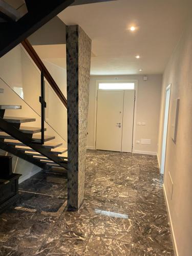 an empty hallway with a staircase and marble floors at B&B IL CEDRO in Reggiolo
