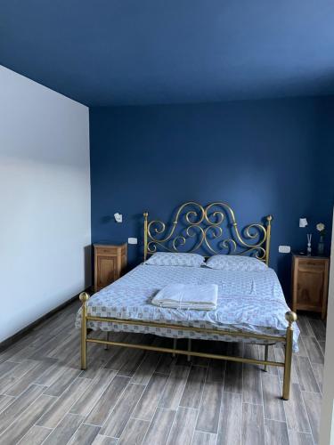 a bedroom with a bed with a blue wall at B&B IL CEDRO in Reggiolo