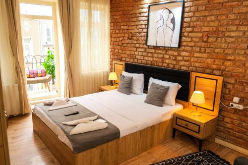 a bedroom with a bed and a brick wall at Taksim Nikea Suites 80 in Istanbul