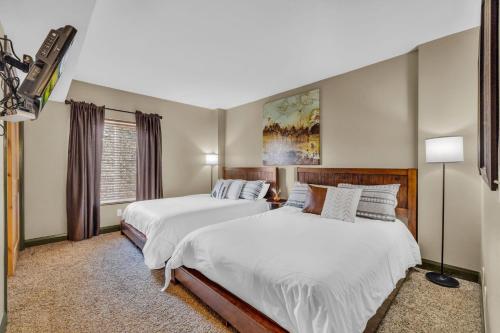 a bedroom with two beds and a painting on the wall at Modern 2BR Condo Near Ski Lift Walk Everywhere in Park City