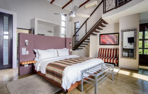 a bedroom with a large bed and a staircase at Francolin Lodge in Nelspruit