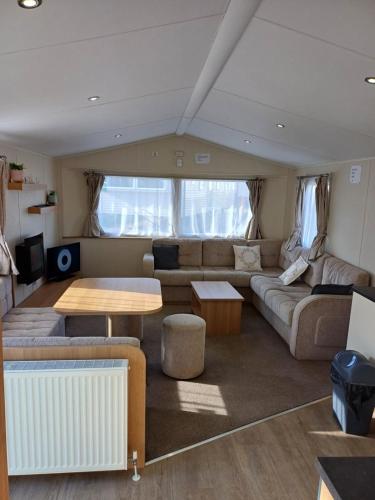 ein Wohnzimmer mit einem Sofa und einem Tisch in der Unterkunft Caravan Holiday Home @ Marton Mere, BLACKPOOL in Blackpool