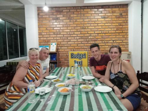 a group of people sitting around a table with food at The Rock Face in Ella