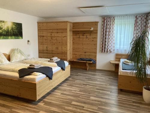 a bedroom with a large bed and a wooden wall at Haus Voithofer in Sankt Johann im Pongau