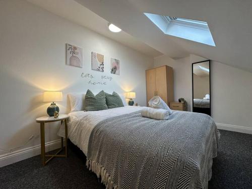 a bedroom with a large bed and a mirror at Cosy, Charming 2-Bedroom Oasis in Ilkeston